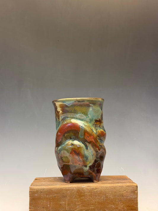 Decorative ceramic piece on a wooden block against a plain background